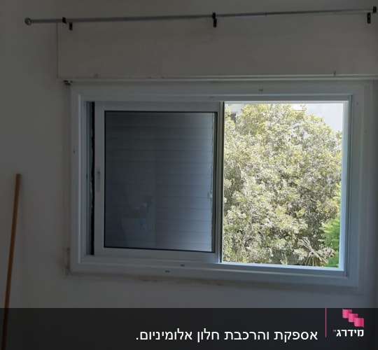 חלון אלומיניום עם תריסים בחדר